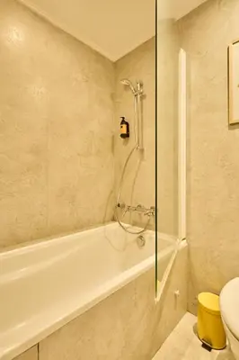 a bathroom with a bath tub and a toilet at Gauthier Pearl - Luxury 3BR Apartment in Casablanca