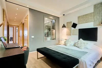 a bedroom with a bed and a desk with a laptop at Gauthier Pearl - Luxury 3BR Apartment in Casablanca