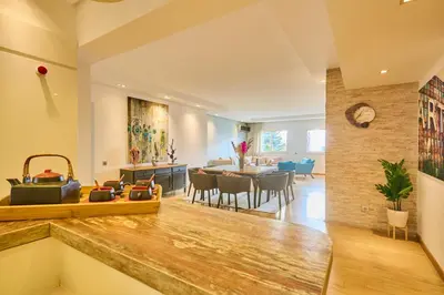 a living room with a table and a dining room at Gauthier Pearl - Luxury 3BR Apartment in Casablanca