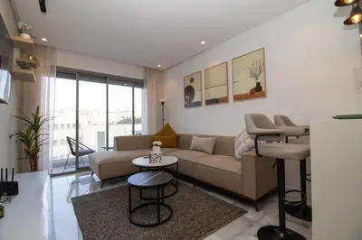 a living room with a couch and a table at Studio Palmier Casablanca in Maarif