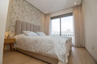 a bedroom with a large bed and a window at Studio Palmier Casablanca in Maarif