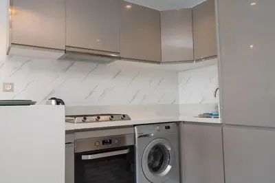 a kitchen with a stove and a washing machine at Studio Palmier Casablanca in Maarif