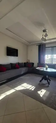 a living room with a couch and a dog on the floor at appartement a louer sable d'or mansouria in Pont Blondin