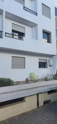 a white building with a bench in front of it at appartement a louer sable d'or mansouria in Pont Blondin