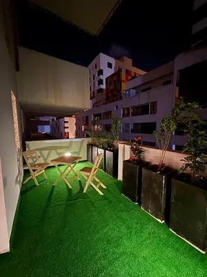 a balcony with a table and chairs on a green lawn at Smile City Homes in Casablanca