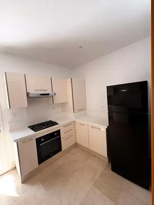 a kitchen with white cabinets and a black refrigerator at Smile City Homes in Casablanca