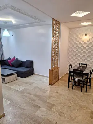 a living room with a couch and a table at bel appartement in Temara