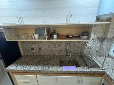 a kitchen with white cabinets and a counter top at bel appartement in Temara