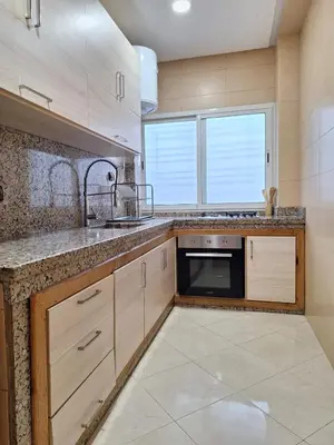 a large kitchen with a sink and a window at bel appartement in Temara
