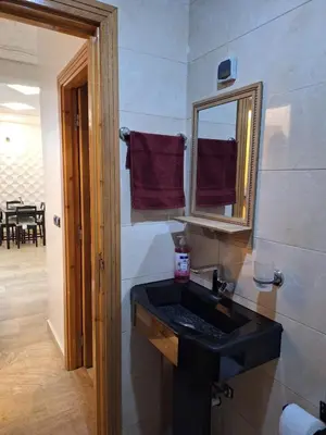 a bathroom with a black sink and a mirror at bel appartement in Temara