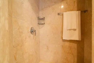 a bathroom with a shower with a white towel at Exceptional Penthouse Private Terrace & Pool in Bouznika