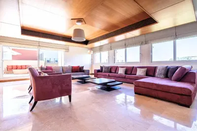 a living room with couches and tables and windows at Exceptional Penthouse Private Terrace & Pool in Bouznika