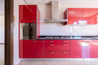 a red kitchen with red cabinets and a stove at Exceptional Penthouse Private Terrace & Pool in Bouznika