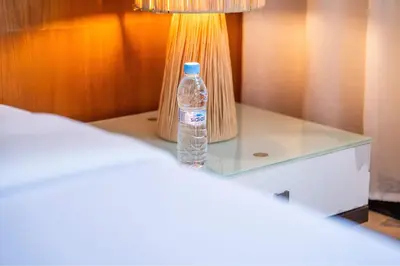 a bottle of water sitting on a table next to a lamp at Exceptional Penthouse Private Terrace & Pool in Bouznika