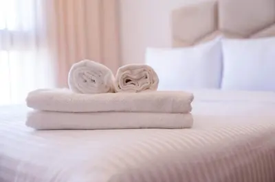 a pile of towels sitting on top of a bed at Cozy Studio with Pool & Parking in Aïn Harrouda