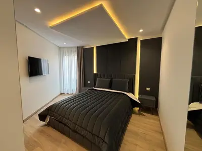 a bedroom with a large bed and a television at Corniche Casablanca - Kimberly Luxury Suite in Casablanca