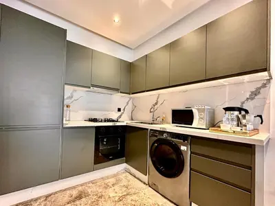 a kitchen with a washing machine and a microwave at Spacious, Quiet Apartment with Parking , Fiber in Casablanca