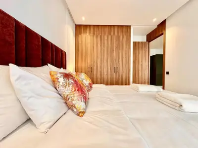 a large white bed with a pillow on it at Spacious, Quiet Apartment with Parking , Fiber in Casablanca