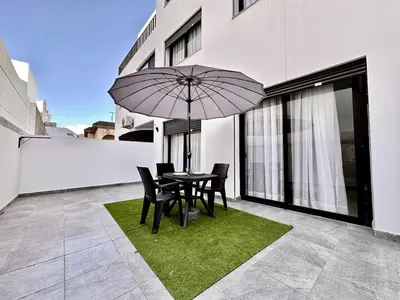a patio with a table and chairs and an umbrella at Spacious, Quiet Apartment with Parking , Fiber in Casablanca