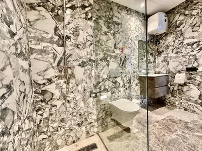 a bathroom with a toilet and a glass shower at Spacious, Quiet Apartment with Parking , Fiber in Casablanca