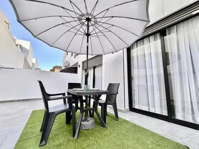 a table and chairs with an umbrella on a balcony at Spacious, Quiet Apartment with Parking , Fiber in Casablanca