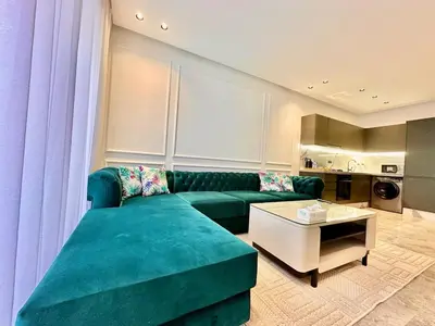 a living room with a green couch and a table at Calm Studio in Oasis, Near Train Station in Casablanca