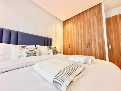 a bedroom with a large white bed with a blue headboard at Cozy, Elegant Apartment, Parking and Fiber in Casablanca
