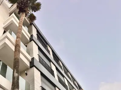 a building with two palm trees in front of it at Cozy, Elegant Apartment, Parking and Fiber in Casablanca