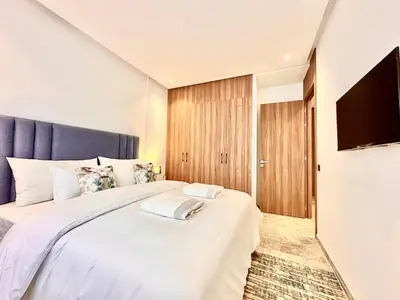 a bedroom with a large white bed with a blue headboard at Cozy, Elegant Apartment, Parking and Fiber in Casablanca