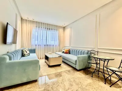 a living room with two blue couches and a table at Oasis Studio - Parking, Fiber, Near the Station in Casablanca