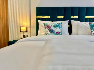 a bedroom with a white bed with a blue headboard and pillows at Oasis Studio - Parking, Fiber, Near the Station in Casablanca