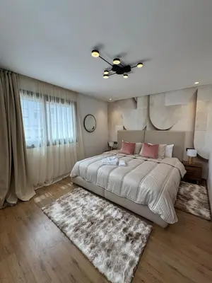 a bedroom with a large bed and a ceiling fan at Modern Studio France ville in Casablanca