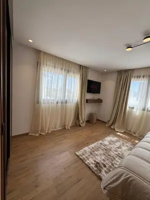 a bedroom with white curtains and a bed and a rug at Modern Studio France ville in Casablanca