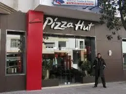 a man standing in front of a pizza hut at Appartement Familial Emile Zola in Casablanca