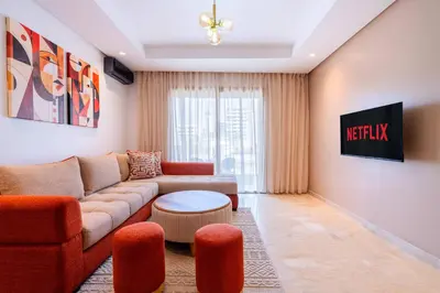 a living room with a couch and a table at Modern Apartment Pool Balcony & Comfort in Aïn Harrouda