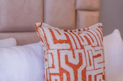 an orange and white pillow sitting on top of a bed at Modern Apartment Pool Balcony & Comfort in Aïn Harrouda