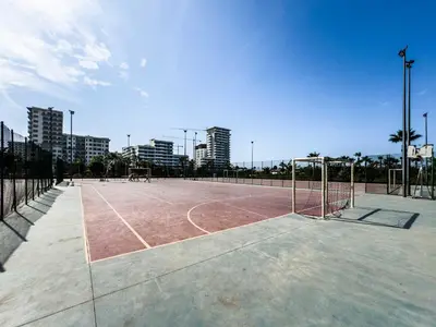 a tennis court with a net in a city at Modern Apartment Pool Balcony & Comfort in Aïn Harrouda