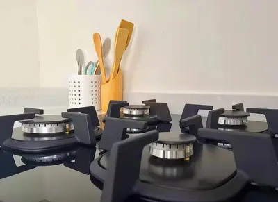 a black stove top oven with utensils in a kitchen at MAYA SUITES - Corniche Seaside in Casablanca