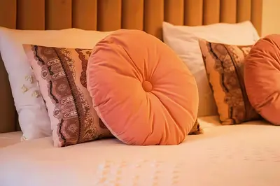 a pillow sitting on top of a bed with pillows at MAYA SUITES - Corniche Seaside in Casablanca