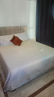 a bed with an orange pillow on top of it at Studio maarif 75m residense ferme in Casablanca