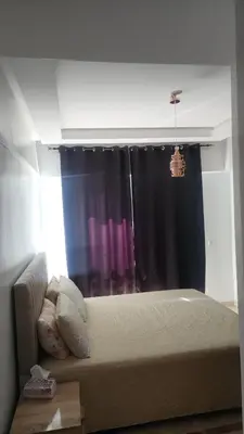 a bedroom with a bed and a window with purple curtains at Studio maarif 75m residense ferme in Casablanca