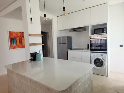 a kitchen with a white counter top and a refrigerator at The Nineteen Racine by IB Signature - Stylish two-Bedroom flat - Wifi, Self Check-in, Day and Night Security, Terrace, free parking, close to all amenities in Casablanca