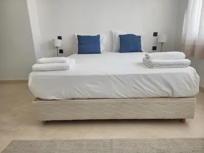 a large white bed with blue pillows on it at The Nineteen Racine by IB Signature - Stylish two-Bedroom flat - Wifi, Self Check-in, Day and Night Security, Terrace, free parking, close to all amenities in Casablanca