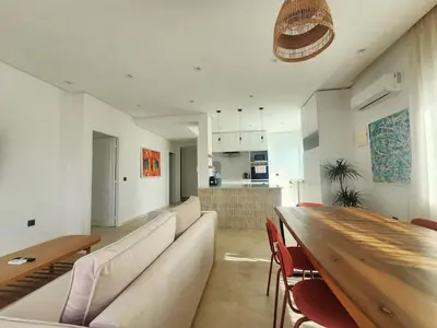a living room with a long couch and a wooden table at The Nineteen Racine by IB Signature - Stylish two-Bedroom flat - Wifi, Self Check-in, Day and Night Security, Terrace, free parking, close to all amenities in Casablanca