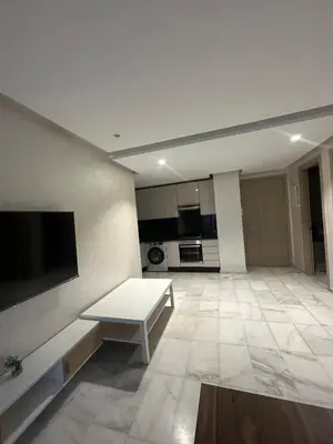a living room with a white table and a tv at Studio de luxe, lumineux et parfait in Casablanca