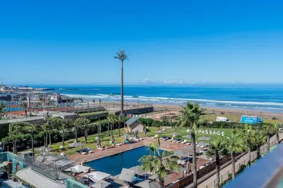 a view of a beach with a pool and palm trees at C07- Pestana - Luxury Hotel Flat - Terrace - Pool in Casablanca
