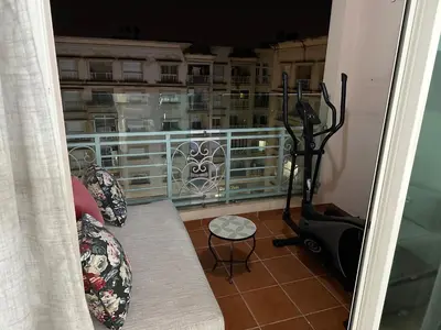 a room with a balcony with a treadmill and chairs at Appartement Haut standing in Mohammedia