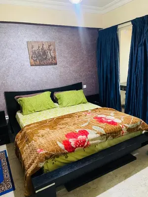 a bedroom with a bed with a comforter and flowers at Résidence in Casablanca