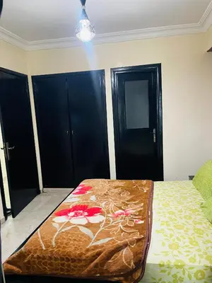 a bedroom with a bed and two black doors at Résidence in Casablanca