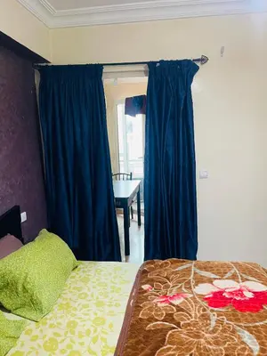 a bedroom with a bed with blue curtains and a table at Résidence in Casablanca